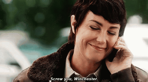 a woman is talking on a cell phone and smiling while saying screw you winchester .