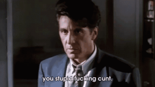 a man in a suit and tie is saying " you stupid fucking cunt " .