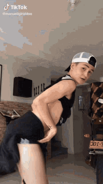 a young man is dancing in a living room with a motorcycle in the background .