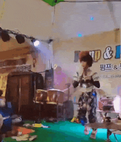 a person playing drums in front of a sign that says ' np & 1 ' on it