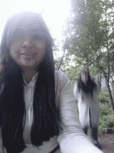 a woman taking a selfie with a blurred background