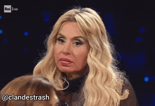 a woman with blonde hair is talking to another woman with the hashtag @clandestrash below her