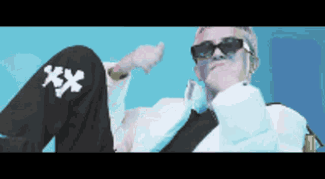 a pixelated image of a man wearing sunglasses and a white coat