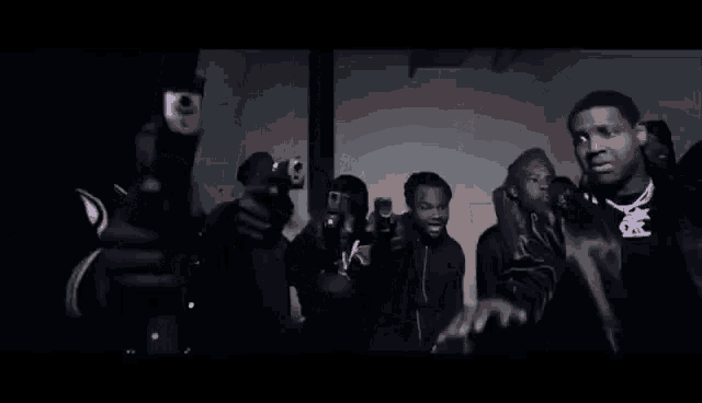 a group of men are standing next to each other in front of a purple light .