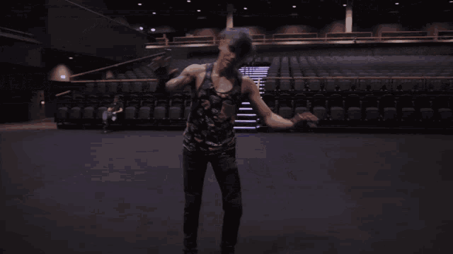 a person walking in an empty auditorium with stairs