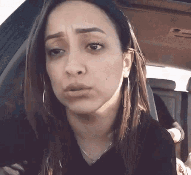 a woman is making a funny face while sitting in a car