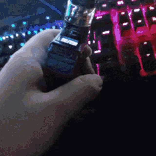 a person is holding a device in front of a keyboard