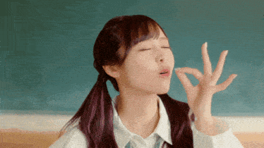 a girl with pigtails is making an ok sign with her fingers