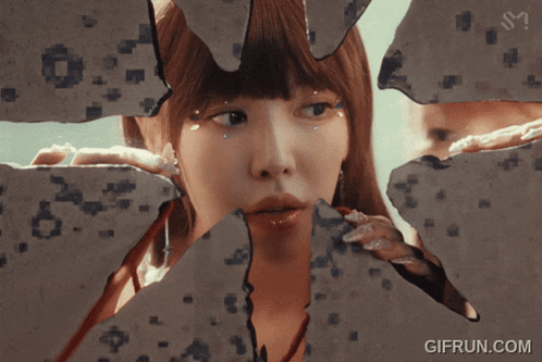 a woman is looking through a broken piece of glass with the website gifrun.com below her