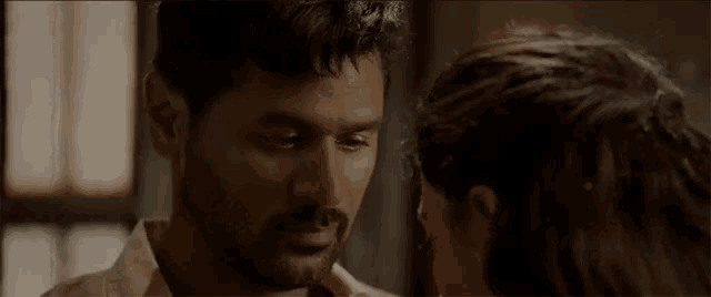 a man and a woman are looking at each other in a dark room .