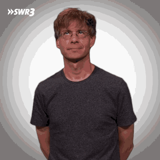 a man wearing glasses and a gray shirt with swr3 on the bottom right