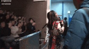 a woman is standing in front of a crowd of people in a room .