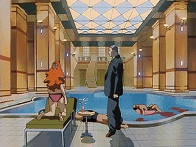 a man in a suit stands in front of a swimming pool with two women in bikinis