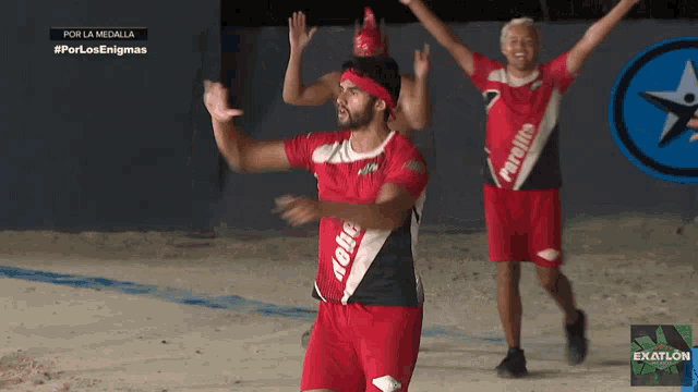 a man wearing a red shirt that says por la medalla on it