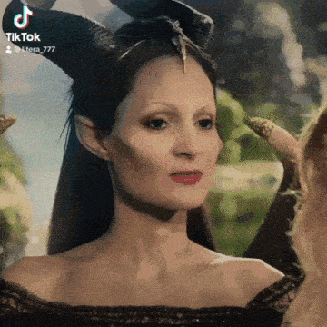 a woman with horns on her head and a black dress