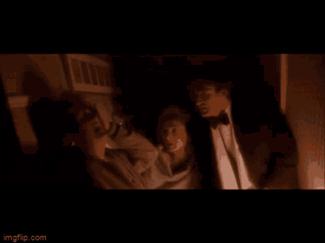 a man in a tuxedo and bow tie is standing next to a woman in a white shirt