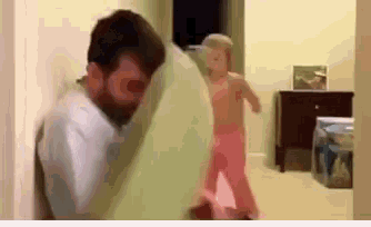 a man and a little girl are playing in a room .