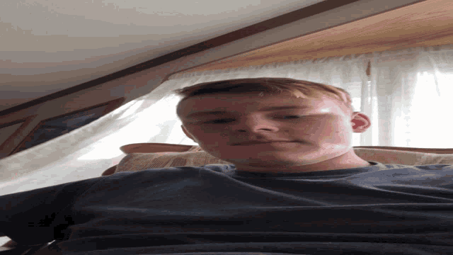 a man with red hair and a blue shirt is looking down at the camera