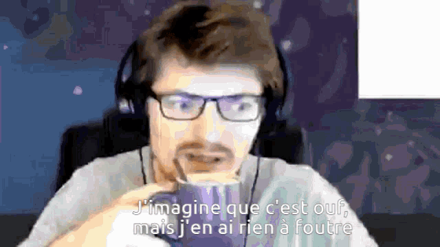 a man wearing glasses and headphones is drinking from a cup