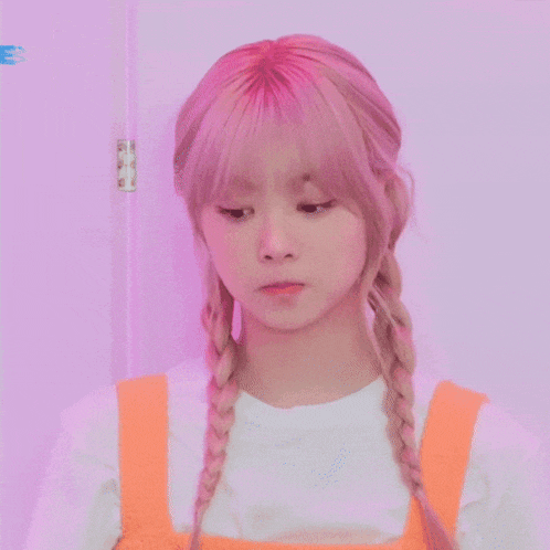 a girl with pink hair and braids is wearing an orange overall