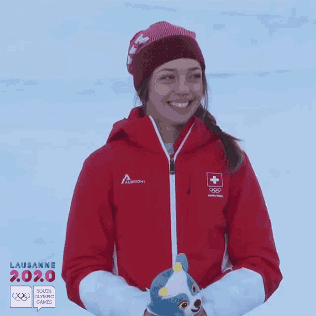 a woman wearing a red jacket that says lausanne 2.0.0
