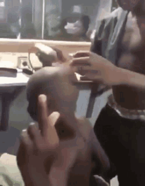 a man without a shirt is holding another man 's head in his hands