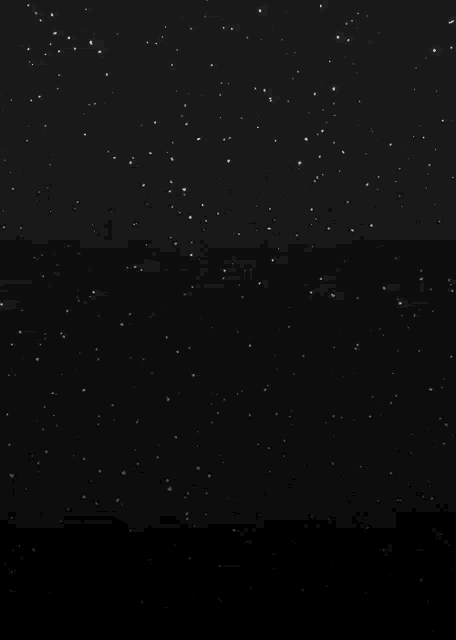 a shooting star is visible in the night sky above a cluster of stars