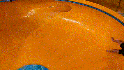 a man is going down a water slide at a water park .