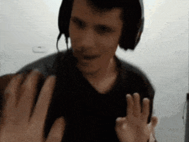a man wearing headphones is giving a high five to someone
