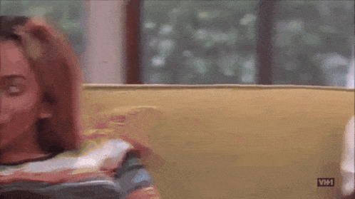 a person sitting on a couch with a vh1 logo on the bottom right