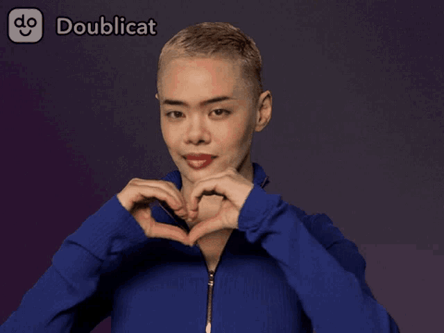 a woman in a blue jacket is making a heart shape with her hands in front of a doublecat logo