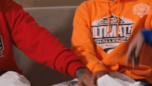 a man wearing an orange ultimate challenge hoodie
