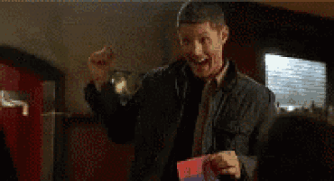 a man in a black jacket is holding a card that says i love you .