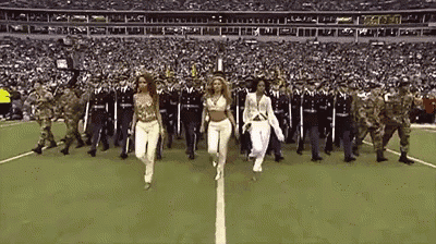 a group of soldiers are marching on a football field