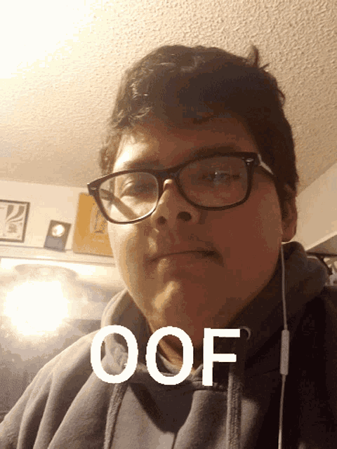 a young man wearing glasses and a hoodie has the word oof written on his face