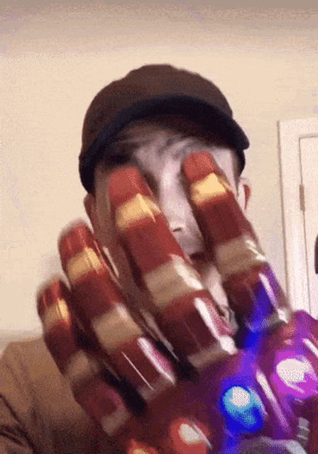 a man wearing a hat and a glove that looks like an iron man hand