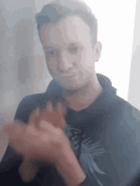 a man wearing a black shirt is clapping his hands