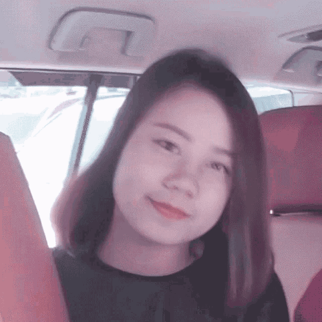 a woman is sitting in the back seat of a car and looking at the camera