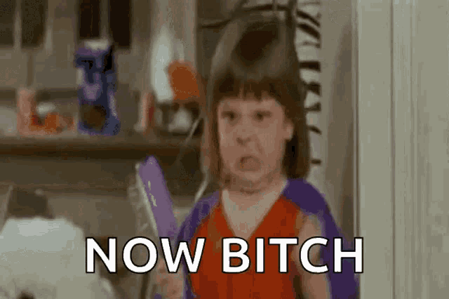 a little girl is making a funny face while holding a mirror and saying `` now bitch '' .