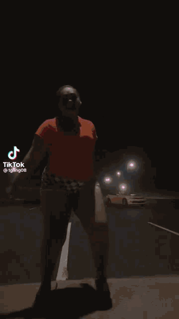a woman is dancing in a parking lot with a yellow car in the background