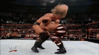 two wrestlers are fighting in a wrestling ring .