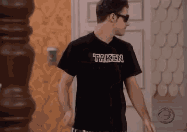 a man wearing sunglasses and a black taken shirt