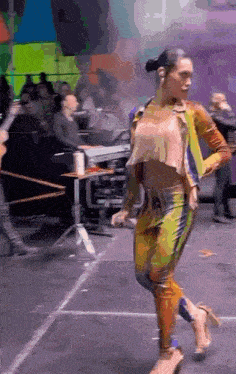 a woman is dancing on a stage in front of a crowd