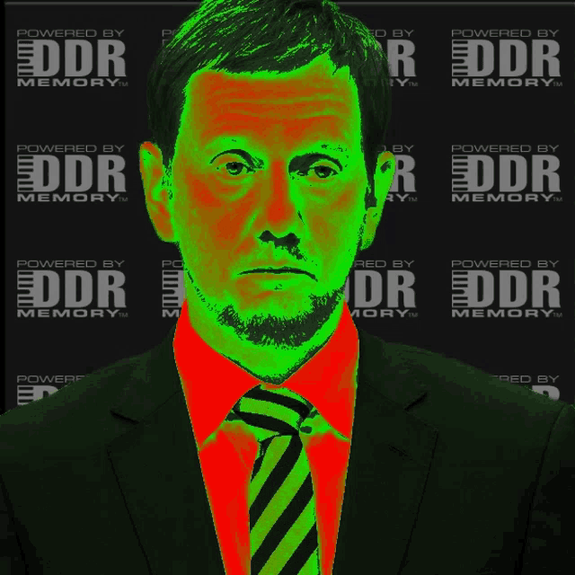 a man in a suit and tie stands in front of a wall that says ddr