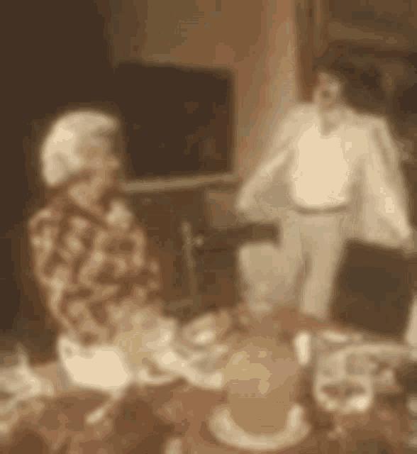 a blurry picture of a man and a woman sitting at a table .