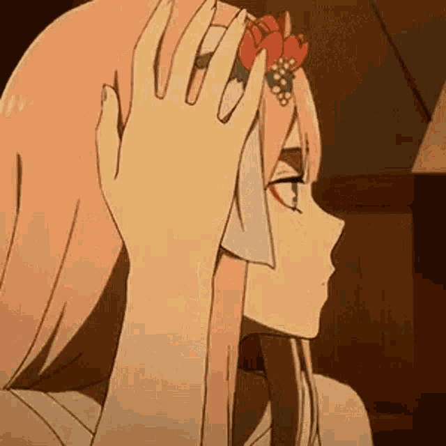 a close up of a person holding a flower in their hair .