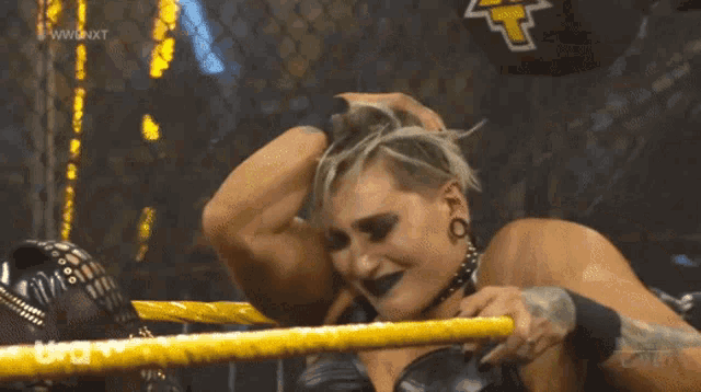 a female wrestler in a ring with a t on her back