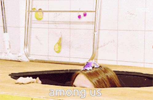 a woman is sticking her head out of a hole that says " among us "