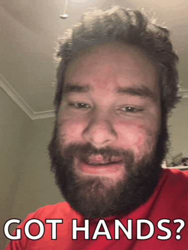 a man with a beard is wearing a red shirt and says got hands