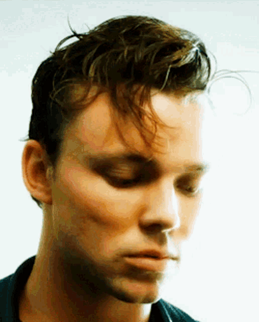 a close up of a man 's face with his eyes closed and his hair visible
